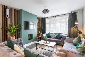 a living room with couches and a tv at Melrose- Beautiful 4 Bedroom Home With Parking in Brighton & Hove