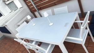 a white table and chairs on a balcony at Stylish and renovated house in Cullera