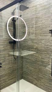 a glass shower with a white ring on the wall at Stylish and renovated house in Cullera +17 photos