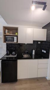 a kitchen with white cabinets and a sink at Monoambiente Nuevo en Belgrano in Buenos Aires