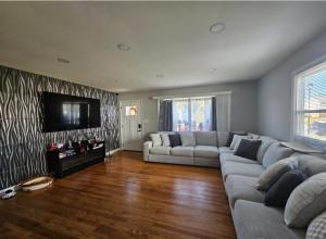 a living room with a couch and a flat screen tv at Welcome in Woodlawn