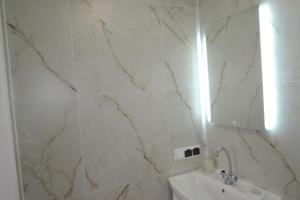 a white bathroom with a sink and a mirror at CityCorner Appartment in Szczecin +25 photos