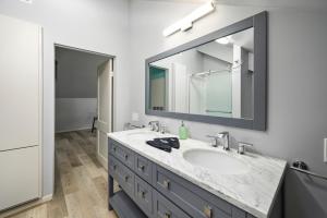 a bathroom with a sink and a large mirror at Cozy & Spacious Montrose Retreat with 3BR Near Houston Attractions in Houston +18 photos