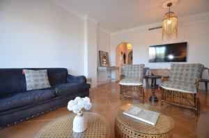 イスラ・デル・モラルにあるSan Bruno Duplex SOLMARESのソファと椅子とテーブルのあるリビングルーム