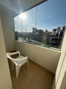 a white chair sitting in front of a window at Centro de Tacna in Tacna