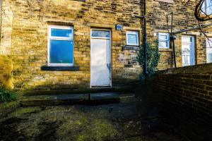 a brick building with a white door and windows at Chic victorian 1 bed flat - sleeps 4 - free parking - pet friendly in Bradford