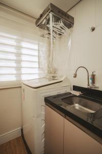a kitchen with a sink and a counter top at Apartamento moderno na Pedra Branca in Palhoça +53 photos
