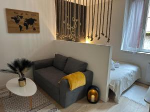 a living room with a couch and a bed at Nuit étoilée in Moissac