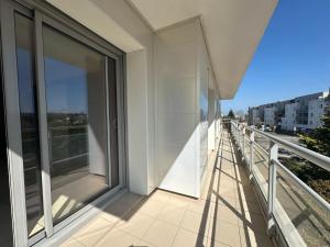 einen Balkon mit Glastüren auf einem Gebäude in der Unterkunft Djimmy hébergement in Saint-Herblain