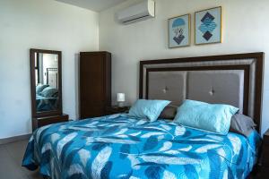 Un dormitorio con una cama con sábanas azules y un espejo. en few steps from the beach, at golden zone, en Mazatlán