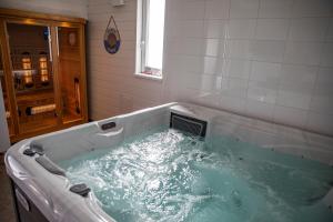 a bath tub filled with water in a bathroom at Ingrid Vendégház és Wellness Pilisszentiván 2 in Pilisszentiván +16 photos