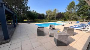 a patio with chairs and a swimming pool at Villa Mahloa in Saint-Yaguen