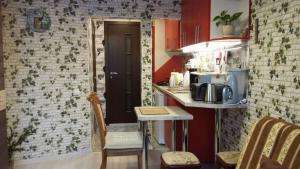 a kitchen with red walls and a table with a microwave at Small and cozy studio apartment in Riga