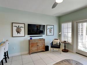 a living room with a television and a table and chairs at Cassine Station 305 - Sea Ya in Santa Rosa Beach