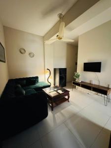 a living room with a black couch and a piano at 2 Bedrooms Deluxe Family Apartment Islamabad-HS Apartments in Islamabad