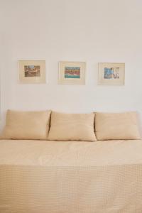 a white wall with three pictures above a bed at Villa Von Sophia in Petriaí