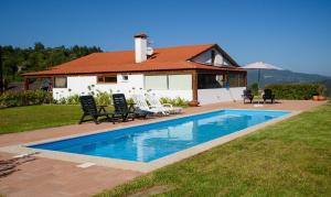 a house with a swimming pool in front of a house at Tapadas do Sol in Couto de Esteves