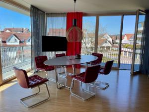 a dining room with a table and chairs and a large window at Ferienwohnung triLogie am See - Schmetterling in Stetten