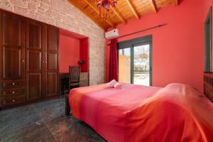 a bedroom with red walls and a large bed at Eleftherias Garden House in Afantou