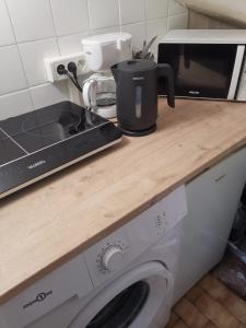 a kitchen counter with a microwave and a washing machine at Studio Asnieres sur Seine équipé et fonctionnelle in Asnières-sur-Seine