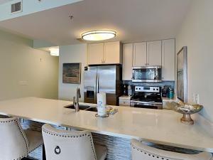 a kitchen with a large counter with chairs in it at Cassine Station 305 - Sea Ya in Santa Rosa Beach +11 photos