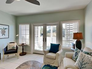 a living room with a couch and chairs and windows at Cassine Station 305 - Sea Ya in Santa Rosa Beach