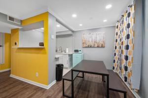 休斯顿Montrose 1BR Apartment with Modern Vibes and Fast WiFi的厨房配有桌子和黄色的墙壁 更多9张照片