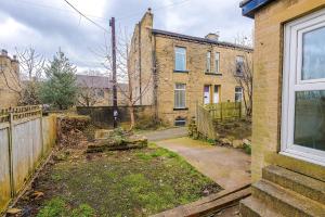 an empty yard in front of a brick house at Charming 2 Bed House, Sleeps 6, Free parking, Contractors welcome in Elland