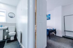 a white bathroom with a toilet and a sink at Charming 2 Bed House, Sleeps 6, Free parking, Contractors welcome in Elland +60 photos
