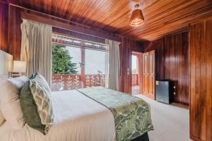 a bedroom with a bed and a large window at Hotel Heliconia - Monteverde in Monteverde Costa Rica +63 photos
