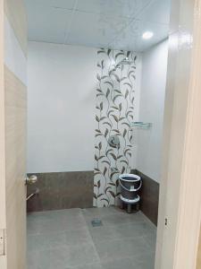 a bathroom with a toilet and a wall at The Royal Luxor 3Bhk Villa in Pune +29 photos
