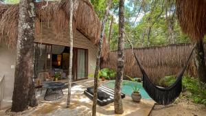 a resort with a hammock and a swimming pool at The Yellow Nest Tulum in Tulum