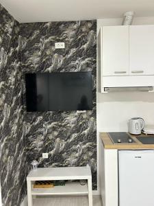 ein Wohnzimmer mit einem Fernseher an der Wand in der Unterkunft M-Home Mostar in Mostar