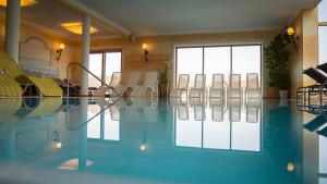 una camera con piscina con sedie di Landhotel Moorhof a Franking