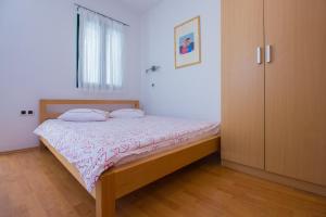 a bedroom with a bed and a cabinet in it at Apartments Petrinic Crnogaj in Baška