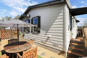 ein kleines Haus mit einem Tisch und einem Sonnenschirm in der Unterkunft Disney Beaches Close Fire Pit Stadiums in Norwalk