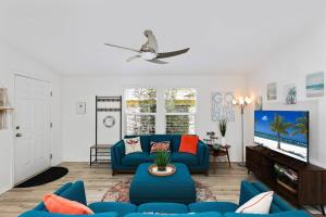 ein Wohnzimmer mit einer blauen Couch und einem Fernseher in der Unterkunft Disney Beaches Close Fire Pit Stadiums in Norwalk