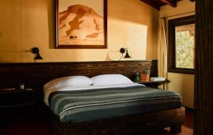 a bedroom with a bed with a green blanket on it at Pioneertown Motel in Pioneertown
