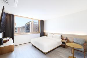 a bedroom with a white bed and a large window at Browndot Paju Heiri in Paju +127 photos