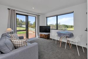 a living room with a couch and a table at Central Couples Retreat - Mangawhai Heads Unit in Mangawhai