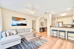 a living room with a couch and a kitchen at Near Disney - Spacious 3BR Condo with Pool in Orlando +18 photos