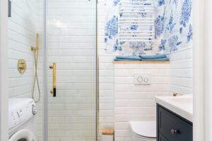 - une salle de bains blanche revêtue de carrelage bleu et blanc dans l'établissement MYE Apartments - Retro Piotrkowska, à Łódź