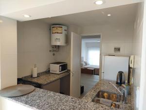 a kitchen with a sink and a refrigerator at Sol de la Perla in Mar del Plata