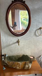 a bathroom with a stone sink and a mirror at La Casinha da Sorte in Sana