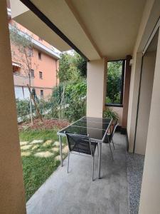 a glass table and chairs on a patio at L'incanto sui colli con giardino privato in Pianoro