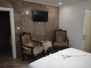 a bedroom with two chairs and a tv on a stone wall at Shantel in Haifa +82 photos