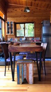 a kitchen with a table and chairs in a cabin at Cabana Fruta Fina - Urubici/SC in Grão Pará