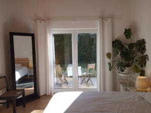 a bedroom with a bed and a sliding glass door at Endless Summer Surf House in Aljezur