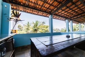 a large wooden table in a room with a large window at Pousada do Joab - Fernando de Noronha in Fernando de Noronha