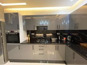 a kitchen with white cabinets and black counter tops at Modern Apartment Airport in Marrakesh